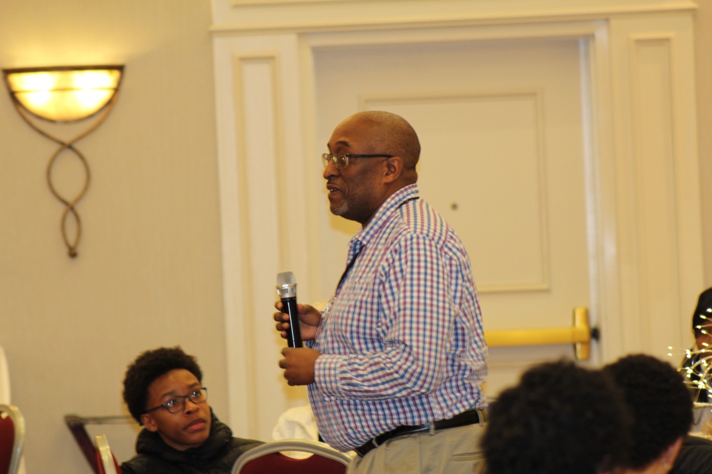 An attendee stands to ask a question during the program.
